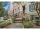 An exterior view of lovely townhomes with brick steps and wrought iron railings leading to covered entryways at 849 Perennial Dr, Atlanta, GA 30328