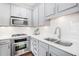 Bright kitchen featuring gray cabinets, white subway tile backsplash, stainless steel appliances, and quartz countertops at 849 Perennial Dr, Atlanta, GA 30328