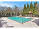 Community pool with deck, furniture, mature landscaping, and trees at 849 Perennial Dr, Atlanta, GA 30328