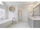 Bright bathroom features a modern tub, double vanity with stone countertops, decorative accents, and updated fixtures at 3966 Creekview Ridge Dr, Buford, GA 30518