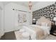 Bedroom with black and white wallpaper, a white bed with decorative pillows, and a chandelier at 3966 Creekview Ridge Dr, Buford, GA 30518
