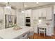 Modern kitchen featuring a white island, desk area, stainless steel appliances, and sleek pendant lighting at 3966 Creekview Ridge Dr, Buford, GA 30518