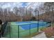Outdoor tennis courts surrounded by mature trees offer a private and active recreational amenity at 3966 Creekview Ridge Dr, Buford, GA 30518