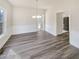 Bright dining room featuring modern gray flooring, decorative trim, and a stylish pendant light fixture at 1200 Platinum Dr, Hoschton, GA 30548