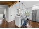 Modern, white kitchen with an island, stainless steel appliances, hardwood floors, and stylish pendant lighting at 1521 Bentcreek Dr, Marietta, GA 30062