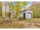 White shed with a garage door plus additional entry and surrounding foliage at 2390 Morgan Ne Rd, Marietta, GA 30066