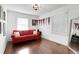 Bright bedroom features a red sofa, natural light, and hardwood floors, creating a cozy and inviting space at 3096 Highland Se Dr, Smyrna, GA 30080