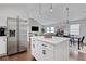 Kitchen featuring a stainless steel refrigerator, a white island with seating and sightlines to other living areas at 3096 Highland Se Dr, Smyrna, GA 30080