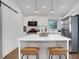 Well-lit kitchen features a white island with seating, stainless steel refrigerator, and classic pendant lighting at 3096 Highland Se Dr, Smyrna, GA 30080