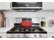 Close-up of a stainless steel stove with a red pot, set against a backdrop of subway tile backsplash at 3096 Highland Se Dr, Smyrna, GA 30080