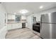 Newly renovated kitchen featuring stainless steel appliances, white cabinets, granite countertops and wood floors at 555 N Lake N Dr, Covington, GA 30016