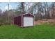 Storage shed with a roll-up door in a lush backyard at 555 N Lake N Dr, Covington, GA 30016