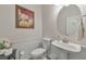 Stylish powder room with pedestal sink, decorative mirror, and attractive artwork at 2415 Clock Face Ct, Lawrenceville, GA 30043