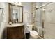 Elegant bathroom featuring a vanity, toilet, and glass-enclosed shower with beige tiles at 3180 Wills Mill Rd, Cumming, GA 30041