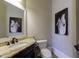 Cozy powder room with granite countertop, dark vanity, and black and white horse artwork at 3180 Wills Mill Rd, Cumming, GA 30041