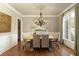 Elegant dining room with chandelier, hardwood floors, and wainscoting details at 3180 Wills Mill Rd, Cumming, GA 30041