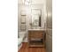 Chic powder room with a wooden vanity, mirror, and stylish decor at 3180 Wills Mill Rd, Cumming, GA 30041