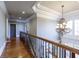 Second-floor hallway boasts hardwood floors, decorative railing, and elegant chandelier at 3180 Wills Mill Rd, Cumming, GA 30041