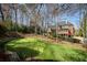 Backyard putting green provides recreational space with mature trees and the home in the background at 3180 Wills Mill Rd, Cumming, GA 30041