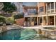 Swimming pool and hot tub with stone accents, outdoor kitchen, and nearby balcony with seating at 3180 Wills Mill Rd, Cumming, GA 30041