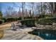 Lounge area with chairs next to a stone swimming pool surrounded by manicured landscaping at 3180 Wills Mill Rd, Cumming, GA 30041