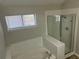 Bathroom featuring a window, a glass shower and soaking tub at 503 N Shore Rd, Lithonia, GA 30058