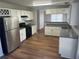 Kitchen with stainless steel appliances, white cabinets, and wood flooring at 503 N Shore Rd, Lithonia, GA 30058