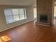 Spacious living room featuring wood flooring, large windows, and a brick fireplace at 503 N Shore Rd, Lithonia, GA 30058