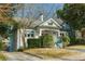 Side view of a quaint white bungalow with a driveway and well-kept landscaping at 648 Cooledge Ave, Atlanta, GA 30306