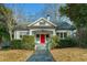 Charming white bungalow with a red front door and manicured landscaping at 648 Cooledge Ave, Atlanta, GA 30306