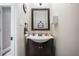 Compact powder room with a dark wood vanity, modern fixtures, and neutral color scheme at 76 Barrington Farms Pkwy, Sharpsburg, GA 30277