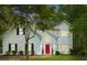 Beautifully lit two-story home with a manicured lawn and a vibrant red front door at dusk at 76 Barrington Farms Pkwy, Sharpsburg, GA 30277