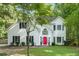 Charming two-story home featuring white siding, black shutters, a well-manicured lawn, and a bright red front door at 76 Barrington Farms Pkwy, Sharpsburg, GA 30277