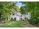 Charming two-story home with a manicured lawn, mature trees, and a vibrant red front door at 76 Barrington Farms Pkwy, Sharpsburg, GA 30277