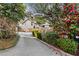 Home exterior showing a paved driveway with lovely flowering trees and landscape surrounding the house at 124 The Prado, Atlanta, GA 30309