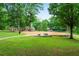 Community playground with swings and playset surrounded by mature trees and green space at 124 The Prado, Atlanta, GA 30309