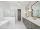 Luxurious bathroom features a freestanding tub, glass shower, double vanity with framed mirrors, and stylish fixtures at 204 Wakehurst Way, Marietta, GA 30064
