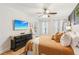 Comfortable bedroom with a ceiling fan, light colored wood floors, natural lighting, a large bed and dresser at 2110 Laurel Mill Way, Roswell, GA 30076