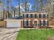 Charming two-story brick home with a well-manicured lawn and two-car garage in a wooded neighborhood at 2110 Laurel Mill Way, Roswell, GA 30076