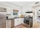 Stylish kitchen features stainless steel appliances, granite countertops, white cabinets and hardwood floors at 2110 Laurel Mill Way, Roswell, GA 30076