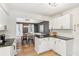 Open-concept kitchen with granite countertops, island seating and a dining area with a modern chandelier at 2110 Laurel Mill Way, Roswell, GA 30076