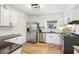 Bright kitchen featuring stainless steel appliances, black countertops, and white cabinets, ideal for cooking and entertaining at 2110 Laurel Mill Way, Roswell, GA 30076