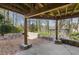 Cozy covered patio featuring stone accents, brick flooring, and a serene wooded backdrop, perfect for outdoor relaxation at 2553 Ridgewood Nw Ter, Atlanta, GA 30318