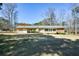 Spacious backyard view featuring a well-maintained lawn, a brick and siding exterior, and mature trees at 4205 S Hurt Sw Rd, Smyrna, GA 30082