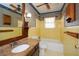 Bathroom featuring vintage yellow tile, decorative wallpaper and wooden cabinets at 4205 S Hurt Sw Rd, Smyrna, GA 30082