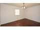 Bedroom featuring hardwood floors, decorative lighting fixture and large window at 4205 S Hurt Sw Rd, Smyrna, GA 30082