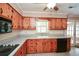 Well-lit kitchen boasting wood cabinets, granite counters, stainless appliances, and a window at 4205 S Hurt Sw Rd, Smyrna, GA 30082
