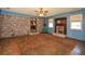 Spacious living room featuring a brick accent wall, fireplace, and access to the kitchen at 4205 S Hurt Sw Rd, Smyrna, GA 30082