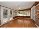 Bright sunroom with hardwood floors, brick accent wall, and multiple windows with natural light at 4205 S Hurt Sw Rd, Smyrna, GA 30082