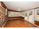Bright sunroom with hardwood floors, brick accent wall, and multiple windows with natural light at 4205 S Hurt Sw Rd, Smyrna, GA 30082